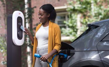 Woman charging her electric vehicle on a TotalEnergies charger